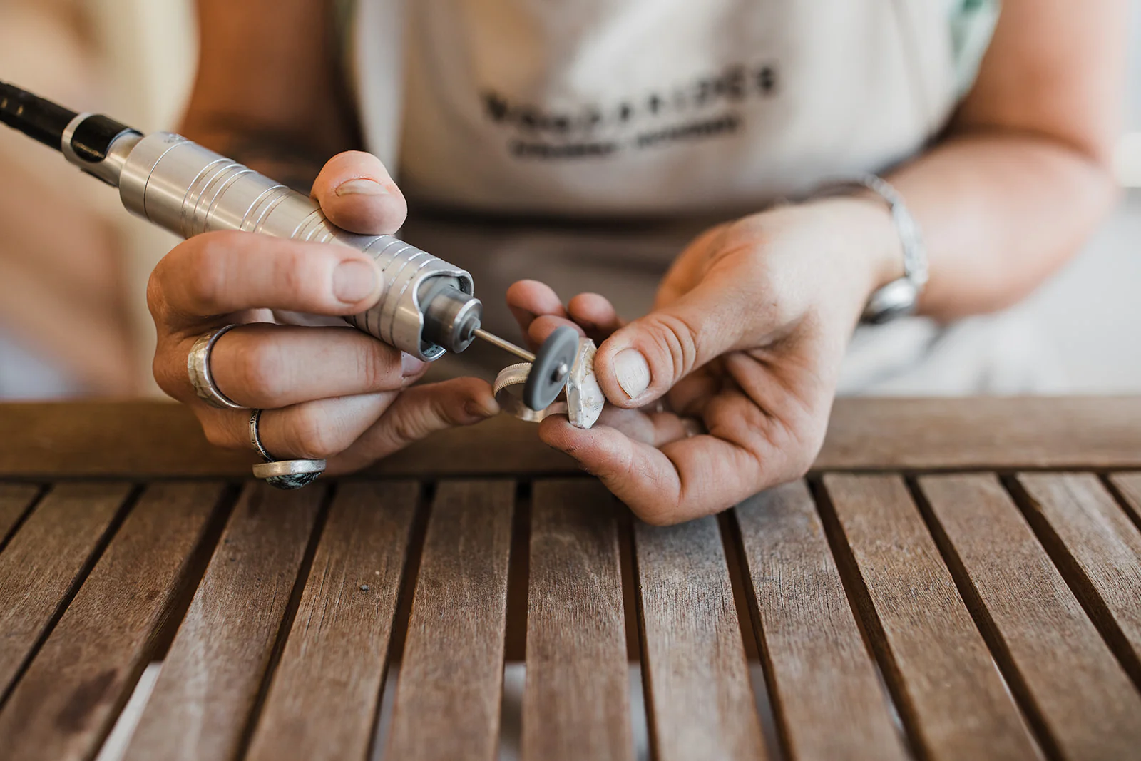 Focus in on a person's hands holding a stone-polishing tool. 